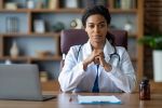 Portrait of attractive black woman doctor posing at clinic