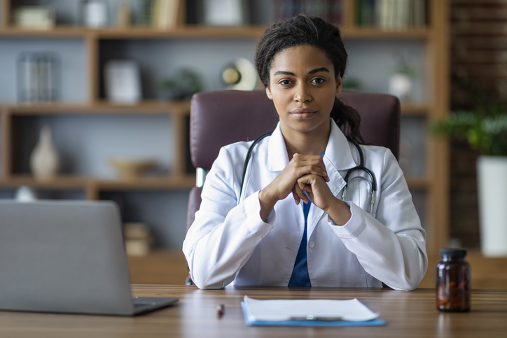 Portrait of attractive black woman doctor posing at clinic