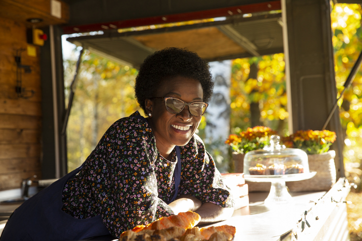 Portrait happy friendly female food cart owner