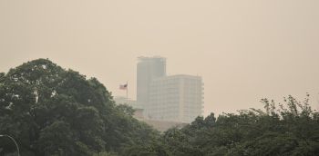 apartment building in haze from forest fires in canada (smog, smoke, fog, air pollution) ebbots field flats in brooklyn with american flag (usa, new york city) wildfires, fumes