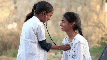 Health checkup, Children medical insurance care. Indian kid doctor of pediatrician holding stethoscope checking heartbeat