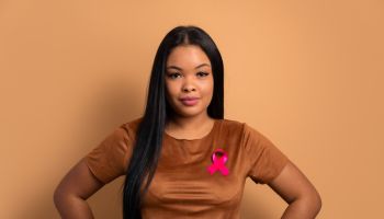 black woman wearing pink ribbon