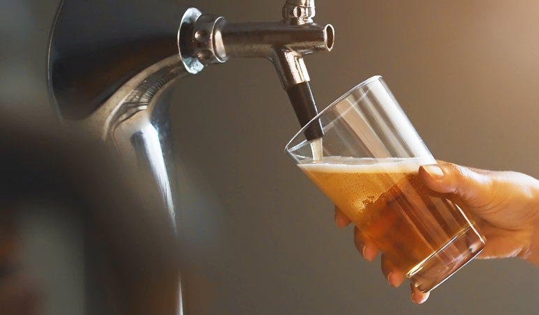 Pouring craft beer into a glass from a keg.