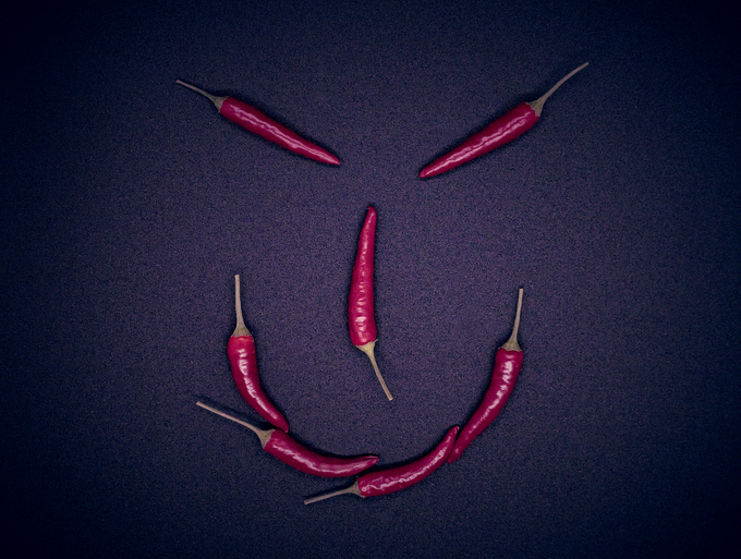 Creative top view studio close up photography of red hot chillies that inspire a devil´s face