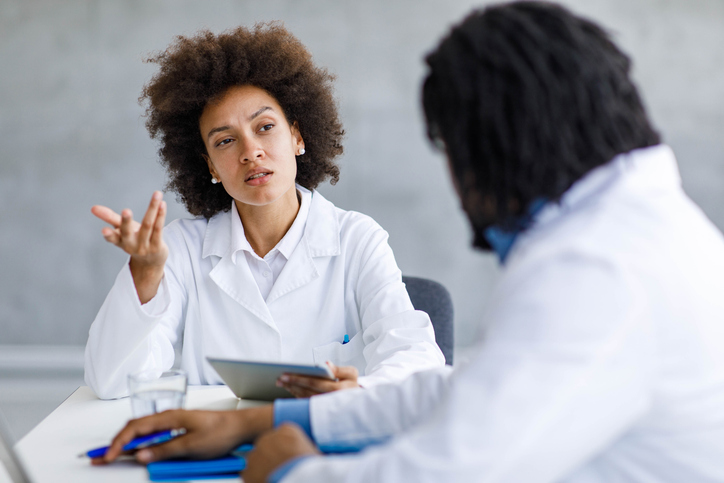 African American doctor talking to her colleague on a meeting in the hospital.
